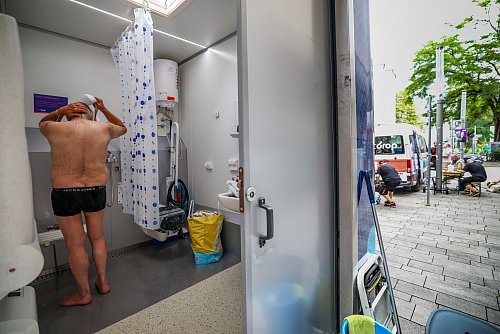 Eine Dusche als Abkühlung - ein Angebot für obdach- und wohnungslose Menschen in der Düsseldorfer Altstadt. - © Christoph Reichwein/dpa