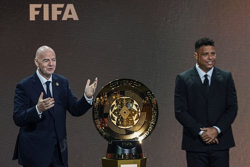 FIFA-Präsident Gianni Infantino und der frühere brasilianische Fußballstar Ronaldo präsentieren bei der Auslosung der Club-WM die Siegertrophäe. - © Rebecca Blackwell/AP/dpa