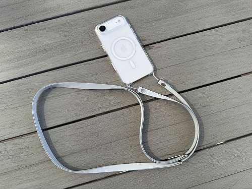 Das neue Crossbody-Band von Apple wird durch kleine Löcher in den iPhone-Hüllen geschlaut und damit befestigt. - © Andrej Sokolow/dpa/dpa-tmn