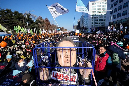 Eine Karikatur eines inhaftierten südkoreanischen Präsidenten Yoon Suk Yeol wird vor einer Kundgebung zur Forderung seiner Amtsenthebung vor der Nationalversammlung gezeigt. Ein zweiter Amtsenthebungsantrag gegen Yoon hat die benötigte Zweidrittelmehrheit in der Nationalversammlung erreicht. - © Ahn Young-joon/AP/dpa