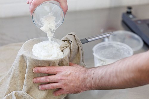 Egal, ob für Joghurtbällchen, Frischkäse oder Quark: Die Masse muss über einem Käsetuch abgeseiht werden. Als Käsetuch eignen sich etwa auch alte, ausgekochte Stofftaschentücher oder Windeltücher. - © Friso Gentsch/dpa/dpa-tmn