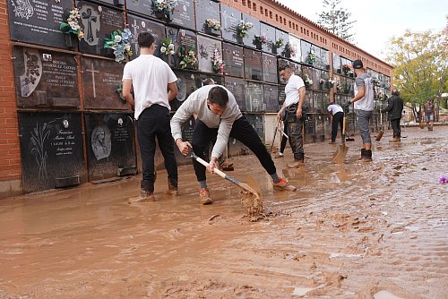 Männer befreien einen überschwemmten Friedhof am Stadtrand von Valencia von Schlamm. - © Alberto Saiz/AP
