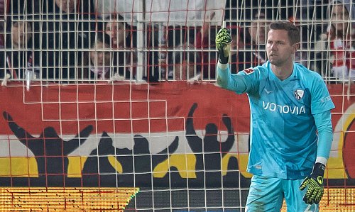 Bochums Keeper Patrick Drewes das Feuerzeug hoch, das ihn getroffen hat. - © Andreas Gora/dpa