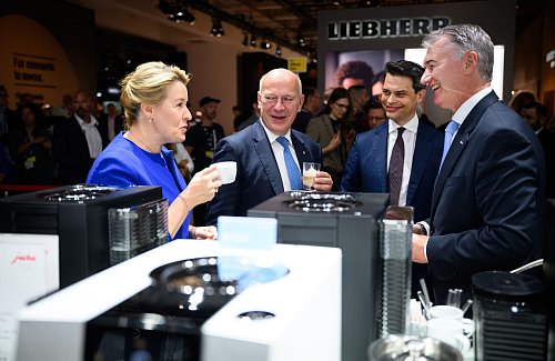 Wirtschaftssenatorin Franziska Giffey lässt sich gemeinsam mit dem Regierenden Bürgermeister Kai Wegner einen Espresso am Stand von Jura Elektrogeräte schmecken. - © Bernd von Jutrczenka/dpa