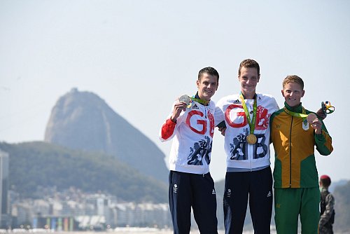 Einer seiner größten Triumphe: Alistair Brownlee (M) nach seinem Olympiasieg in Rio 2016 vor seinem Bruder Jonathan (l) und dem Südafrikaner Henri Schoeman (r) - © picture alliance / dpa