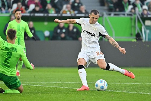 Leverkusens Granit Xhaka (r) beim Torschuss gegen Wolfsburg - © Swen Pförtner/dpa