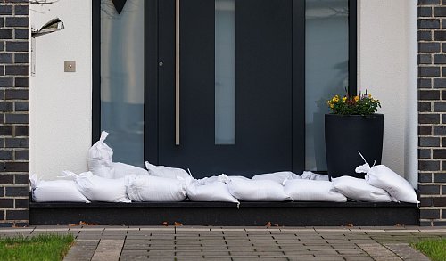 Sandsäcke vor Fenstern und Türen aufzustapeln ist eine einfache und wirksame Methode, um bei Regen Wassereinbruch in den Keller zu verhindern. - © Friso Gentsch/dpa/dpa-tmn