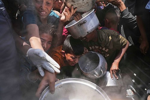 Palästinenser erhalten Lebensmittel in Beit Lahia. - © Jehad Alshrafi/AP/dpa