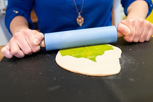 Erst den Ton ausrollen, dann das Blatt darauflegen und langsam mit dem Nudelholz in den Ton drücken. - © Franziska Gabbert/dpa-tmn