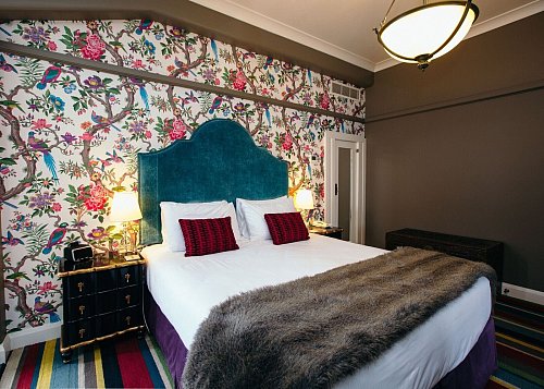 Blick in ein Schlafzimmer des Hotels «Masonic», das zu den Vorzeigegebäuden der Stadt zählt. - © Art Deco Masonic Hotel/dpa-tmn