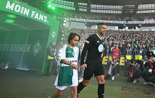 Gemeinsam mit seinem Sohn Matteo betritt Diego bei seinem Abschiedsspiel das Bremer Weserstadion. - © Carmen Jaspersen/dpa