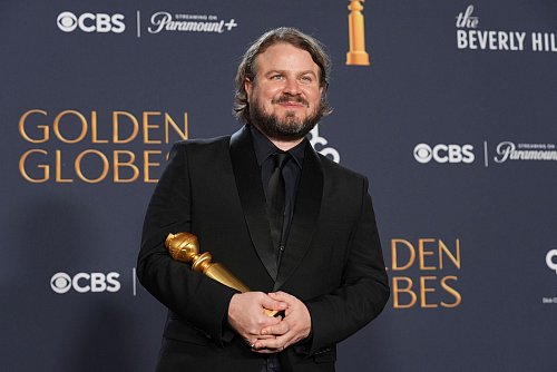 Brady Corbet freut sich über den Regie-Globe. - © Chris Pizzello/Invision/AP/dpa