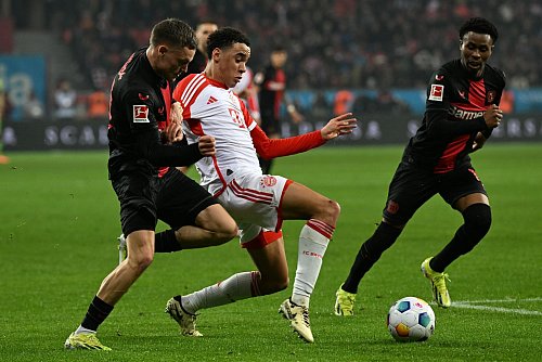 Vereint im Nationalteam, Gegner in der Champions League: Leverkusens Florian Wirtz (l) und Bayerns Jamal Musiala im Kampf um den Ball. - © Federico Gambarini/dpa