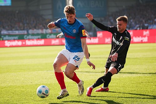 Kiels Lasse Rosenboom (l) und Stuttgarts Maximilian Mittelstädt im Kampf um den Ball. - © Christian Charisius/dpa