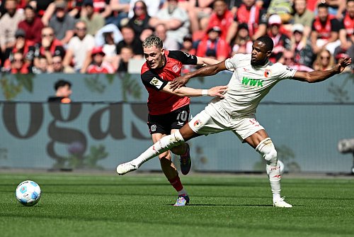 Florian Wirtz (l) leitet das 1:0 für Leverkusen ein. - © Federico Gambarini/dpa