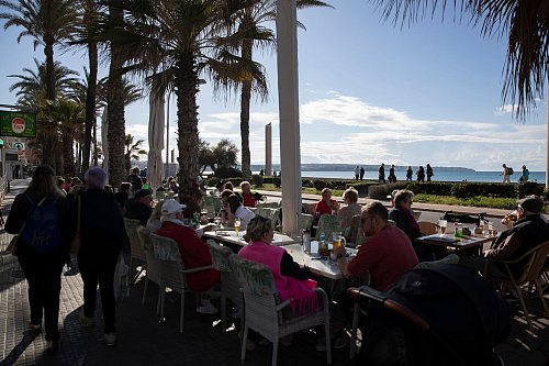 Gut besucht ist bei sonnigem Wetter eine Bar am Strand von Arenal auf Mallorca. - © Clara Margais/dpa