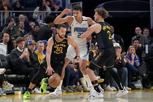 Orlandos Tristan da Silva (Mitte) sammelte gegen All-Star Stephen Curry (l.) zwei Pünktchen. - © Jeff Chiu/AP/dpa