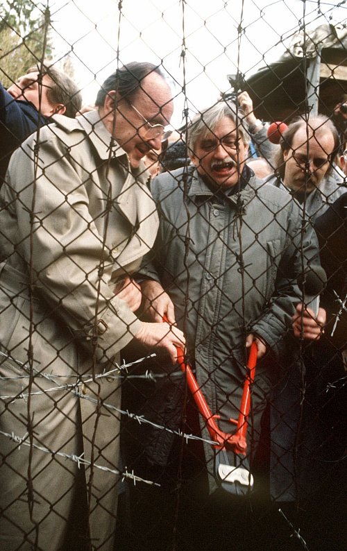 Erst 1989 fällt der sogenannte Eiserne Vorhang zwischen der Tschechoslowakei und Deutschland. Bundesaußenminister Hans-Dietrich Genscher und sein tschechischer Amtskollege Jiri Dienstbier durchschneiden am 23.12.1989 in Rozvadov den Stacheldraht. (Archivbild) - © picture alliance / dpa