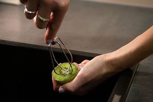 Schritt 1: Den Rührbesen-Aufsatz mittig in die halbierte Kiwi drücken. - © Christin Klose/dpa-tmn