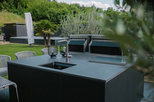 Wer sich ein Spülbecken in seiner Outdoor-Küche wünscht, sollte bei der Standortsuche an den Wasseranschluss denken. - © AMK/dpa-tmn