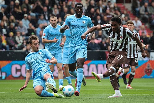 St. Paulis Oladapo Afolayan (r) und Bochums Felix Passlack (l) kämpfen um den Ball. - © Christian Charisius/dpa