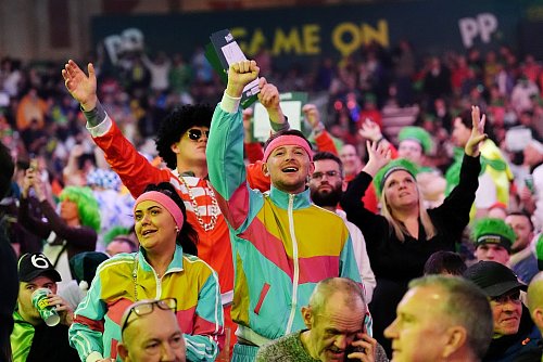 Die Fans genießen die Show von Littler und van Gerwen. - © Zac Goodwin/PA Wire/dpa