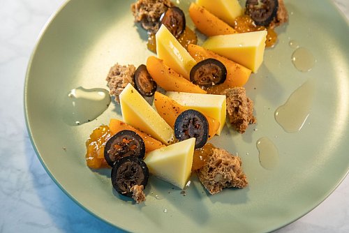 Eine leckere Kombi: Dünne Scheibchen der schwarzen Walnüsse verfeinern den Bergkäse mit frischen Aprikosen, Aprikosenmarmelade und Walnussbrot. - © Christin Klose/dpa-tmn