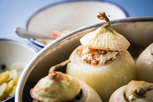 Gefüllte Zwiebel fleischfrei: Hier kommen Feta und Paprika in das ausgehöhlte Gemüse hinein. Der Deckel wird nach dem Befüllen wieder aufgesetzt. - © Christin Klose/dpa-tmn