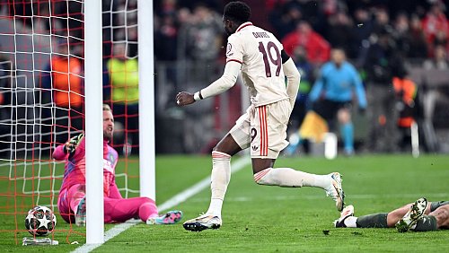Alphonso Davies stochert den Ball ins Tor, am Boden Celtic-Torwart Kasper Schmeichel (l). - © Sven Hoppe/dpa
