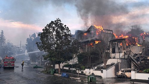 Feuerwehrleute arbeiten in Los Angeles daran, einen Hausbrand zu löschen. - © Damian Dovarganes/AP/dpa
