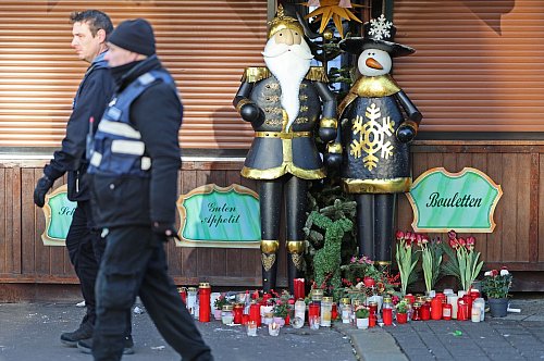 Auch vor den geschlossenen Weihnachtsmarkt-Buden legten Trauernde Blumen ab. - © Matthias Bein/dpa