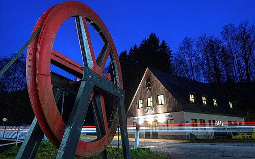 Eine alte Förderscheibe steht vor dem Markus-Röhling-Stolln in Annaberg-Buchholz. In dem Besucherbergwerk wird der alte bergmännische Brauch der Mettenschicht gepflegt. - © Hendrik Schmidt/dpa