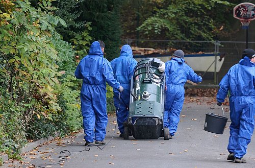 Arbeiter reinigen nach einem Brand in Hamm die Umgebung von asbesthaltigen Rückständen. (Archivbild) - © Bernd Thissen/dpa