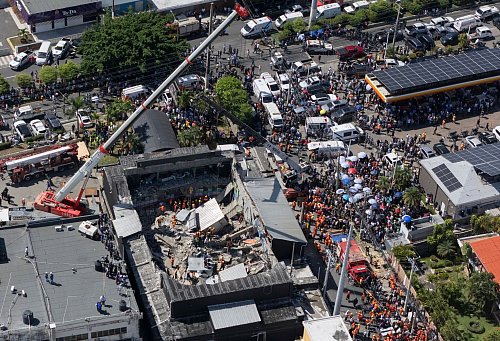 Einsatzkräfte suchen nach Verschütteten. - © Eddy Vittini/AP/dpa