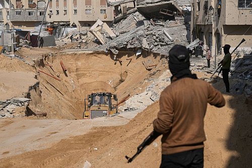 Mitglieder der islamistischen Hamas suchen nach Leichen israelischer Geiseln. - © Abdel Kareem Hana/AP/dpa