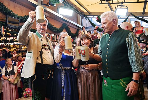 Bayerns Ministerpräsident Söder (l.) und Münchens OB Reiter (r.) stoßen mit ihren Ehefrauen auf eine friedliche Wiesn an. - © Peter Kneffel/dpa