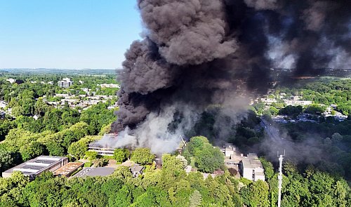 Nach dem Ausbruch eines großen Feuers in einem Schulzentrum in Erkrath bei Düsseldorf kämpfen Einsatzkräfte weiterhin gegen den Brand. - © Gianni Gattus/dpa