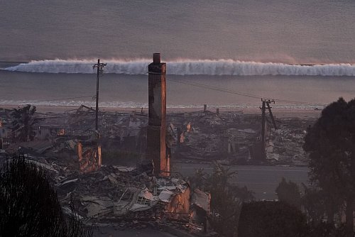 Durch das sogenannte Palisades-Feuer zerstörte Häuser stehen am Strand - es ist der größte der aktuell wütenden Waldbrände in und um die Metropole Los Angeles. - © Mark J. Terrill/AP/dpa