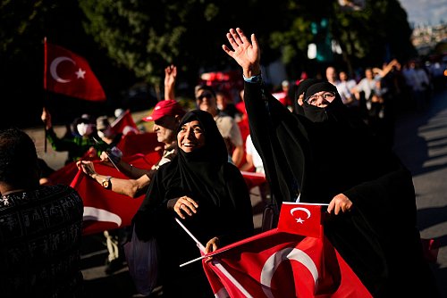 Menschen halten türkische Flaggen hoch, während sie sich zu Ehren der Opfer des gescheiterten Putschversuchs vom 15. Juli 2016 versammelten. (Archivbild) - © Francisco Seco/AP/dpa