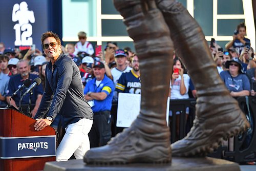 Brady blickt während seiner Rede auf seine frisch enthüllte Bronze-Statue vor dem Stadion der Patriots. - © Charles Krupa/AP/dpa