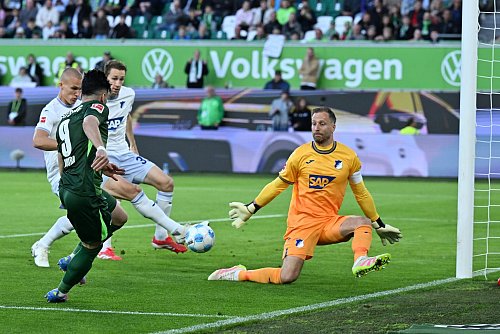 Das Wolfsburger Führungstor: Mohamed Amoura bringt den Ball in die Mitte, Leo Östigaard (l) trifft ins eigene Tor. - © Swen Pförtner/dpa