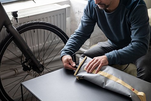 Den Akku für das E-Bike aufladen: Spezielle Taschen mit feuerfestem Garn sollen dafür sorgen, dass im Brandfall das Feuer keinen weiteren Schaden anrichtet. - © Zacharie Scheurer/dpa-tmn