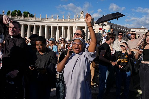 Gläubige telefonieren mit ihren Angehörigen, um vom neuen Papst zu berichten. - © Emilio Morenatti/AP/dpa