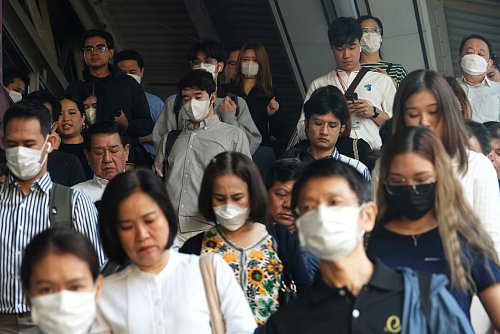 Pendler tragen Gesichtsmasken, um sich vor der Luftverschmutzung zu schützen. - © Sakchai Lalit/AP/dpa
