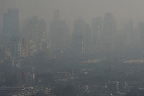 Die Hochhäuser der Metropole sind wegen der Luftverschmutzung kaum sichtbar. - © Sakchai Lalit/AP/dpa
