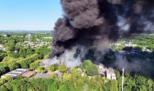 Nach dem Ausbruch eines großen Feuers in einem Schulzentrum in Erkrath bei Düsseldorf kämpfen Einsatzkräfte weiterhin gegen den Brand. - © Gianni Gattus/dpa