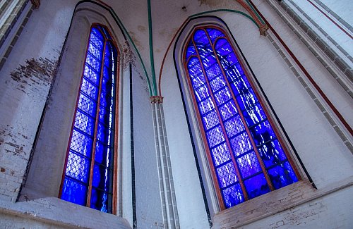 Zwei der vier von Günther Uecker gestalteten großen farbigen Glasfenster im Schweriner Dom. - © Jens Büttner/dpa