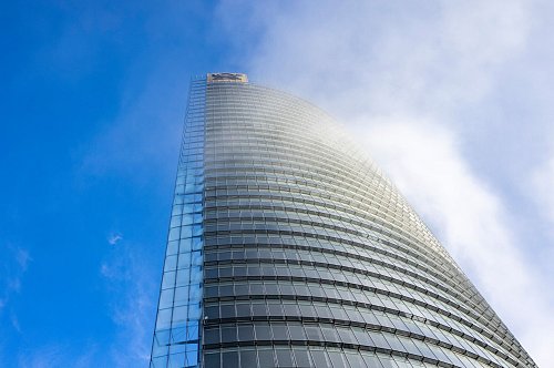 Nebelschwaden ziehen an der DHL-Zentrale am Posttower vorbei. Oben ist das Logo für das Briefgeschäft zu sehen, das Posthorn. - © Thomas Banneyer/dpa