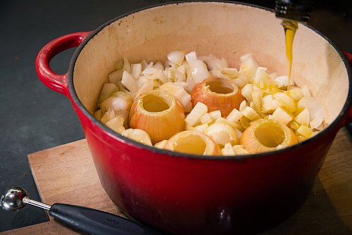 Ausgehöhlte und geschnittene Zwiebeln kommen zusammen mit Olivenöl zum langsamen Garen, dem sogenannten Confieren, für 1,5 Stunden in den Topf. - © Christin Klose/dpa-tmn