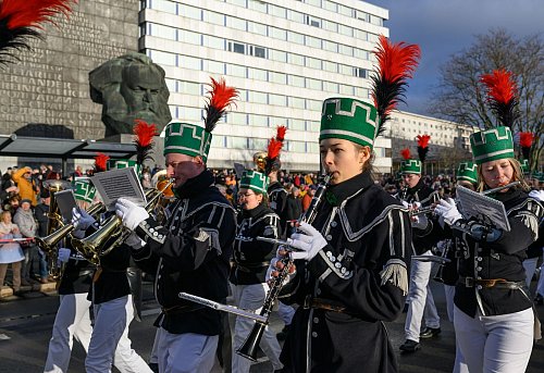 Die Bergparade zum Abschluss des Kulturhauptstadtjahres zieht am Chemnitzer Karl-Marx-Monument vorbei. - © Hendrik Schmidt/dpa